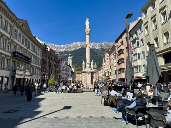 St. Anna's Column (Annasaule) in the center of Innsbruck, with the snow capped Austrian Alps towering beyond the city