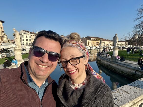 Alex and Bell Kallimanis of wanderlustmarriage.com with statues in the background at Prato della Valle in Padova, Italy.