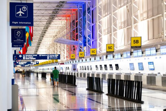 check-in kiosks in an airport terminal with just a few passengers.