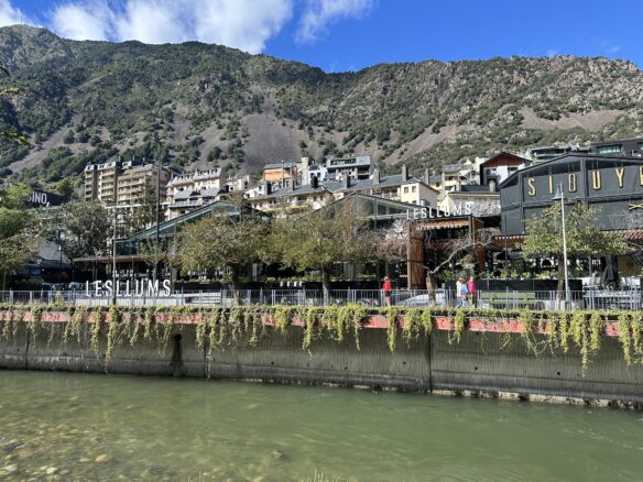 View of the Gran Valira River and building lining the Pyrenees Mountains in Andorra La Vella 