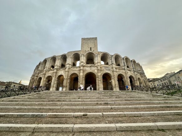 Arles, Arena seen from below the steps at sunset with a cloudy sky.