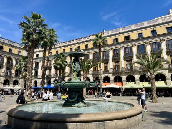 A fountain and tall palm trees highlight Plaça Reial in Barcelona, Spain 