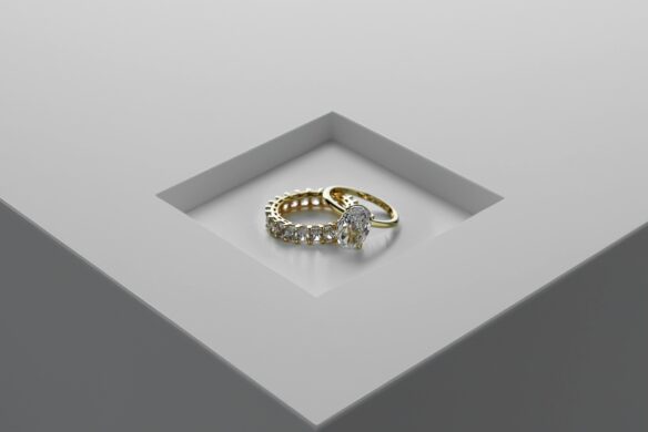 Two gold and diamond rings atop each other.