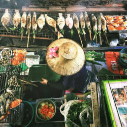 A person grilling a variety of fresh seafood on an open grill.