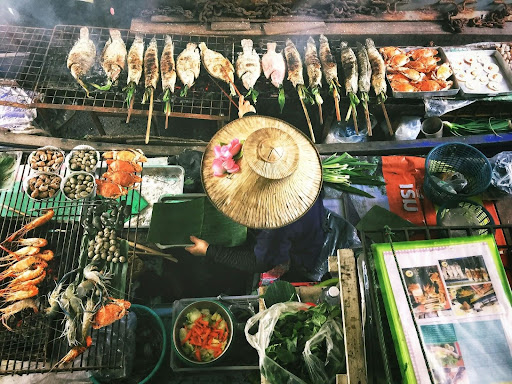 A person grilling a variety of fresh seafood on an open grill.