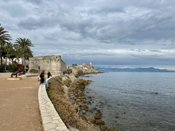 The ramparts and historic quarter of Antibes along the Mediterranean Sea on a cloudy day.