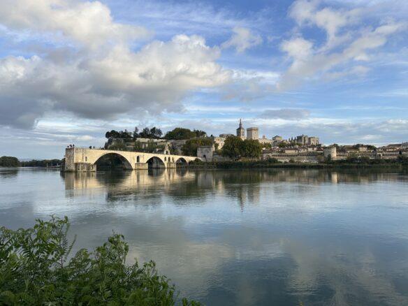 The Pont d'Avignon crosses part of the Rhône River with Avignon in the backdrop.